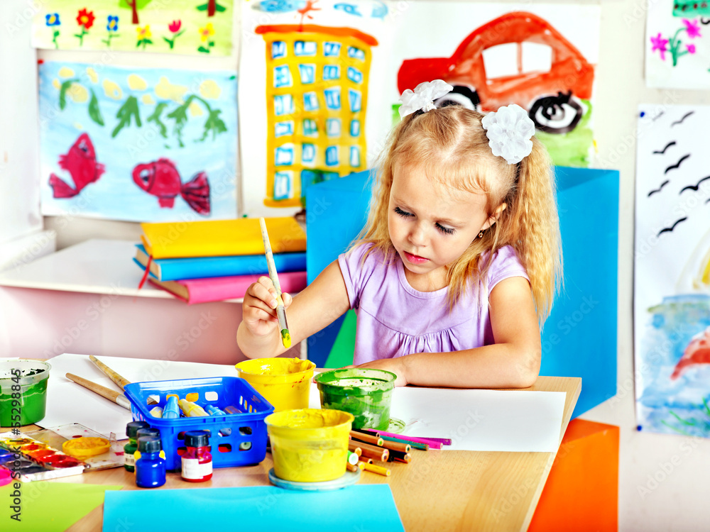 Naklejka premium Child painting at easel.