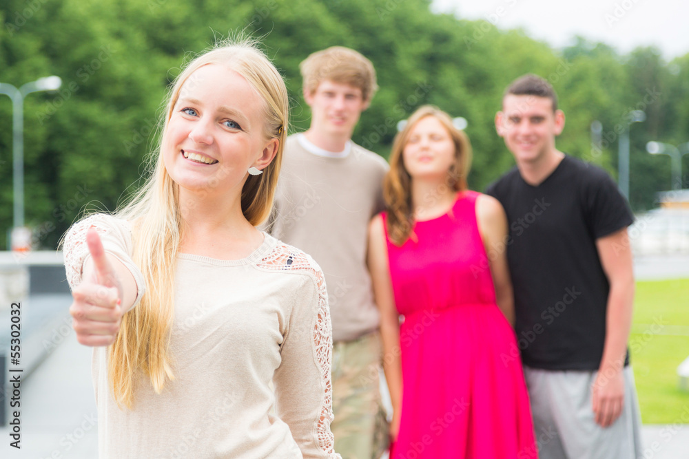 Girl with Thumbs Up and Friends on Background Girl with Thumbs Up and Friends on Background