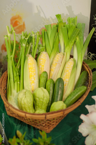 a basket of vegetables, sweet corn, bitter gorud and scallion photo