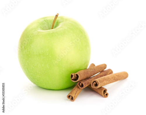 Ripe green apple with cinnamon sticks