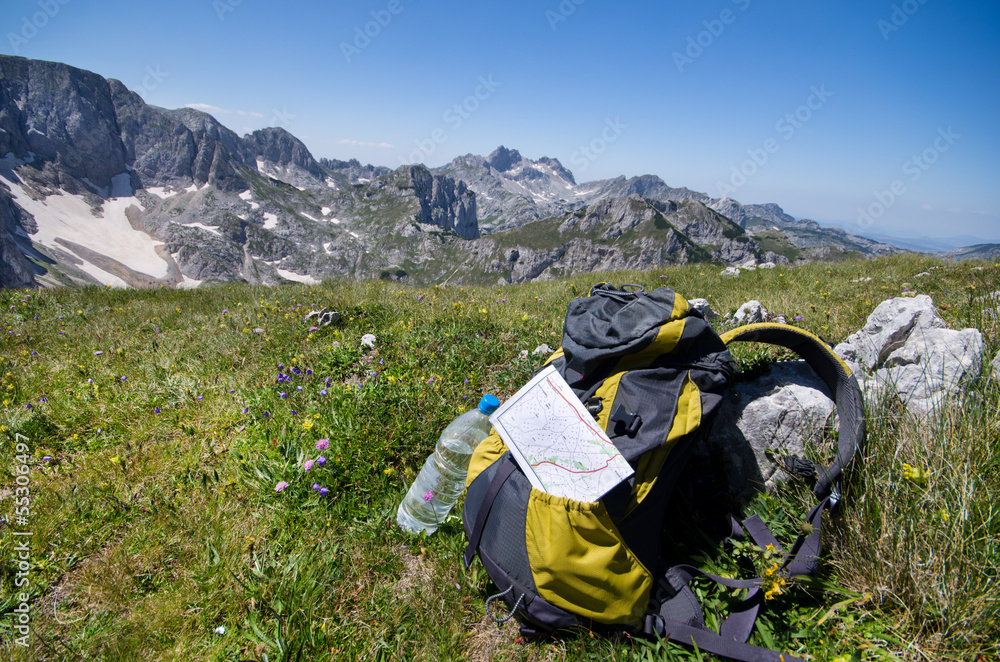 backpack with map and water on peak