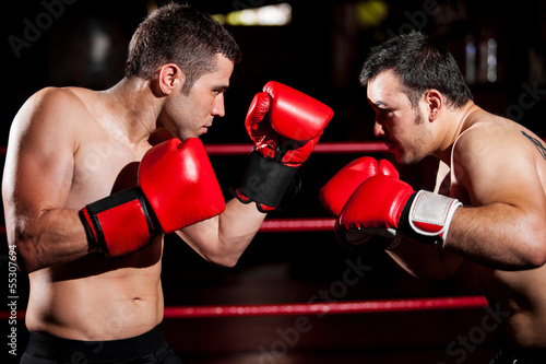 Strong boxer and his opponent during a box fight in a ring