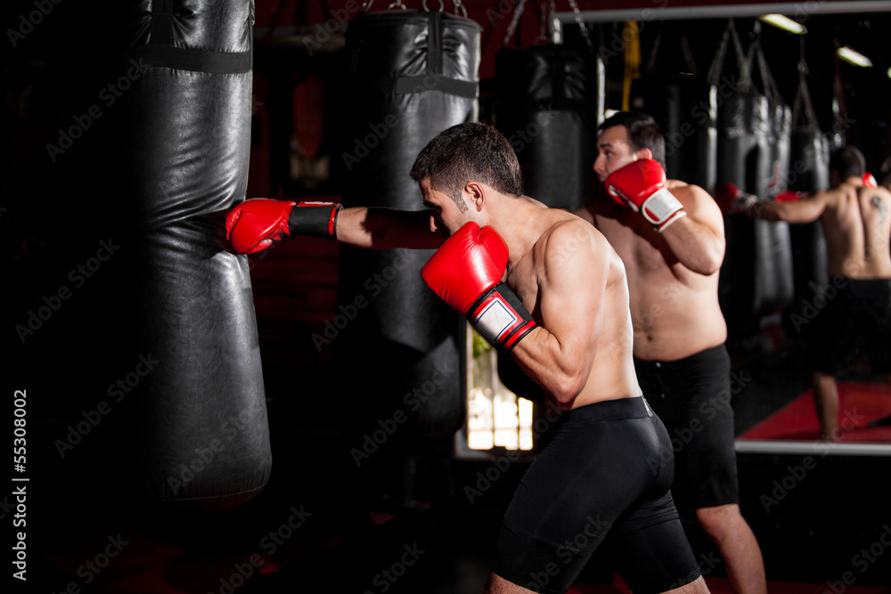 Latin Boxers doing some training on a punching bag at a gym