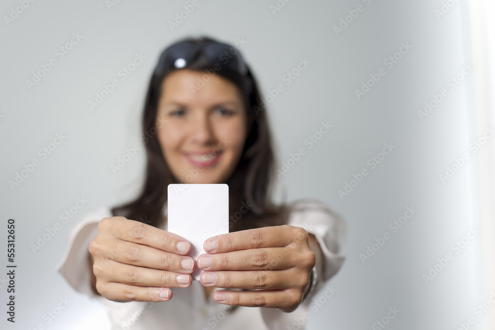 woman holds white plastic card woman holds white plastic card