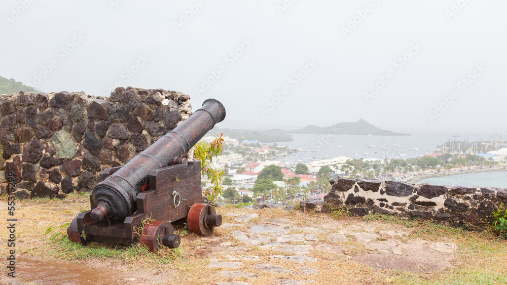 Very old rusted canon pointing at a bay