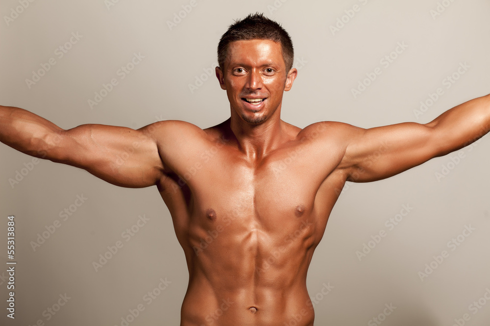 Fototapeta premium muscular handsome man posing on gray background