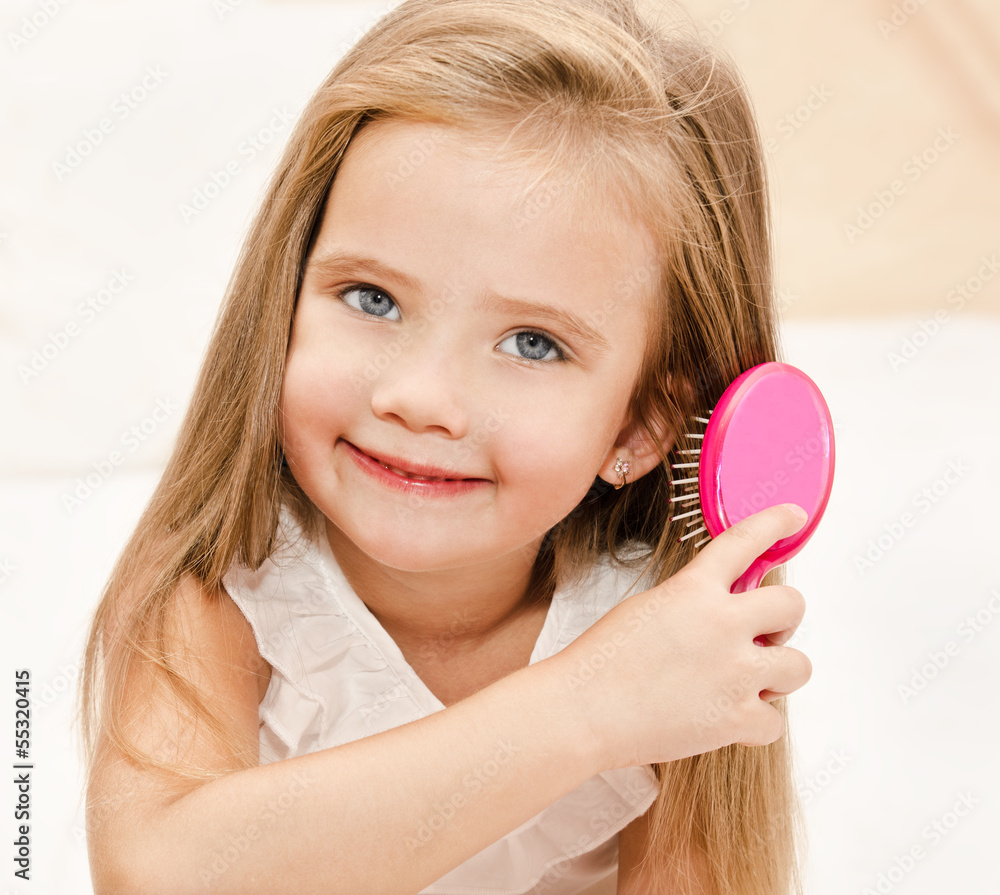 Portrait of smiling little girl brushing her hair Portrait of smiling little girl brushing her hair