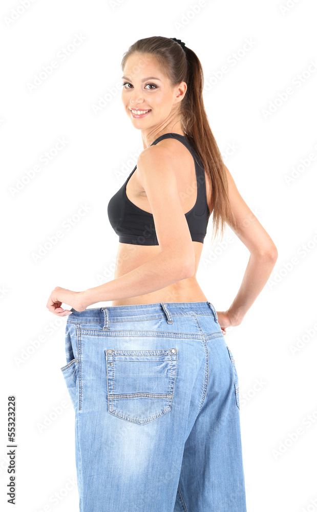 Slim girl in big jeans isolated on white Slim girl in big jeans isolated on white