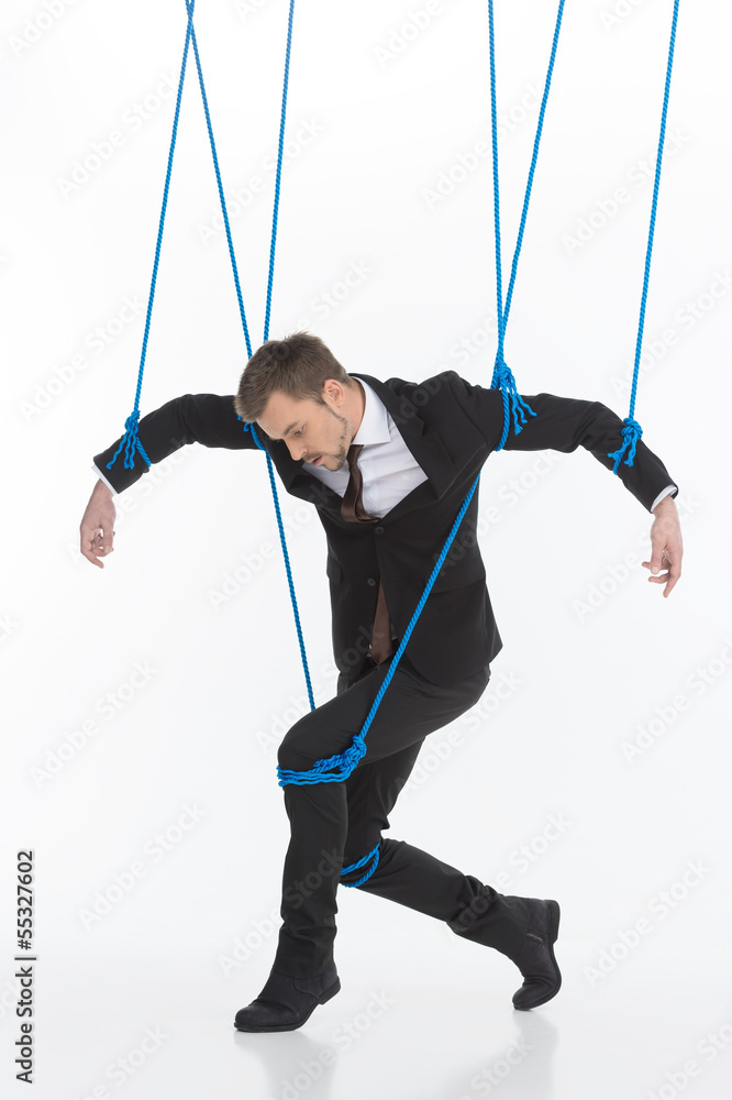 Business marionette. Young man in formalwear looking like marion Business marionette. Young man in formalwear looking like marion