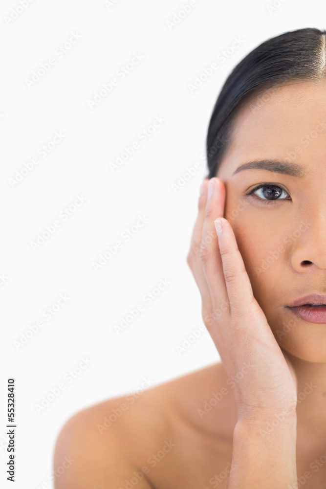 Half face of pensive natural model touching her cheek Half face of pensive natural model touching her cheek
