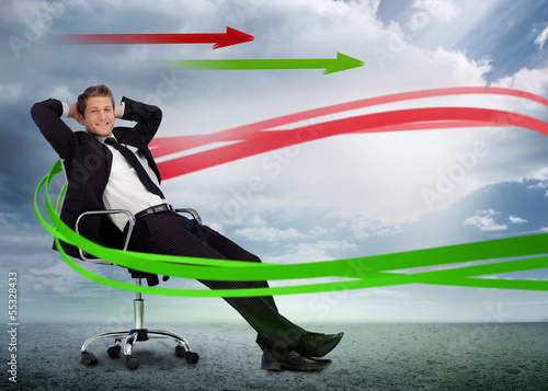 Confident businessman reclining in swivel chair with red and gre