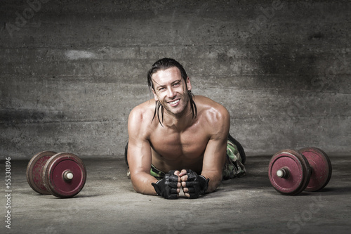 portrait of muscle and smiling athlete lying on the floor