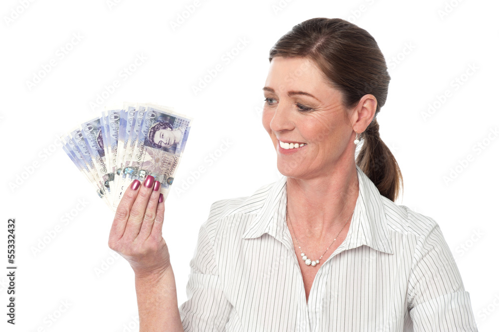 Woman making fan of pound sterling banknotes Woman making fan of pound sterling banknotes