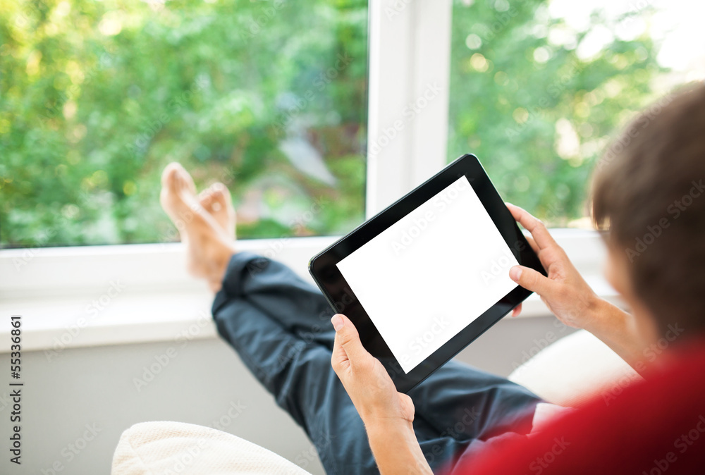 Man using tablet on sofa at home Man using tablet on sofa at home