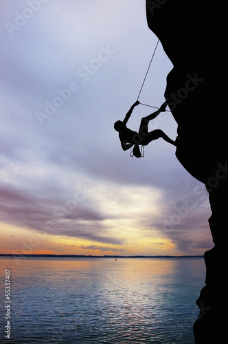 Billede på lærred Rock climber at sunset