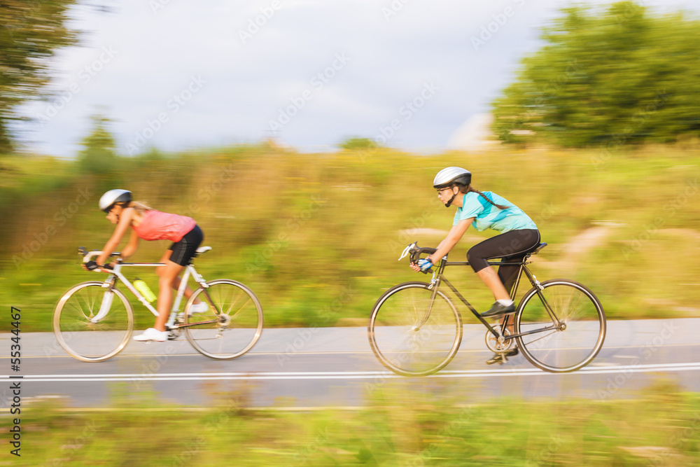 Obraz premium Training process of two female caucasian sportswomen riding spor