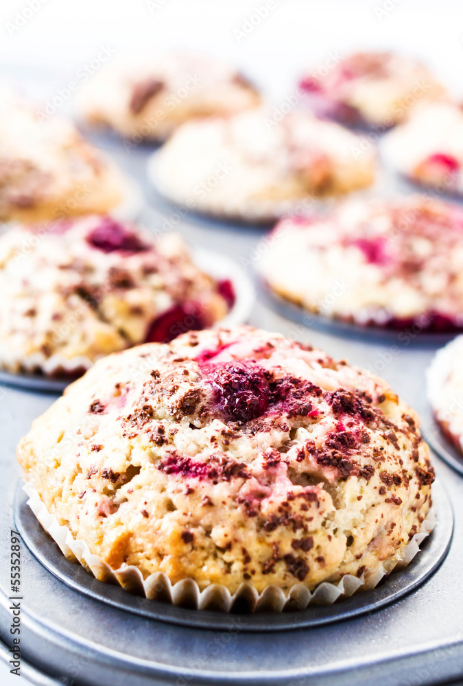 Berry muffins with chocolate sprinkles in baking tray. Closeup. Berry muffins with chocolate sprinkles in baking tray. Closeup.