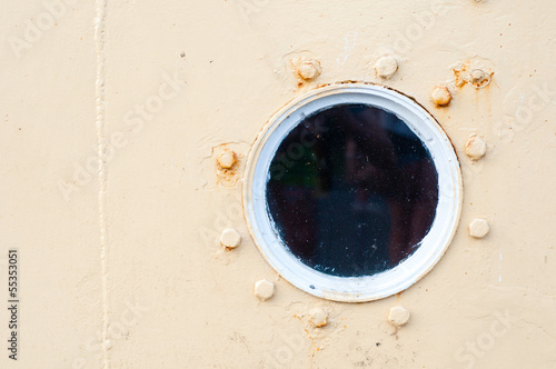 Porthole on the wall of the old ship