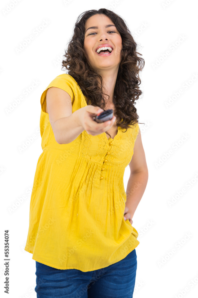 Cheerful curly haired pretty woman changing channel with remote Cheerful curly haired pretty woman changing channel with remote