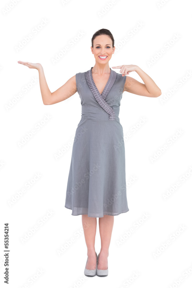 Smiling elegant woman in classy dress showing direction Smiling elegant woman in classy dress showing direction