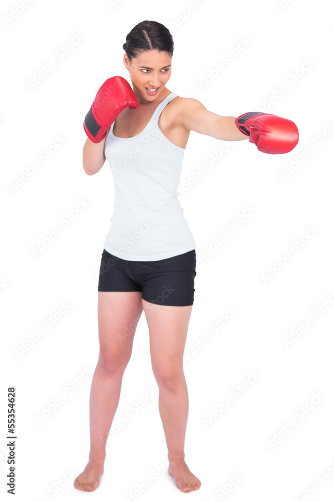 Smiling slender model with boxing gloves punching Smiling slender model with boxing gloves punching