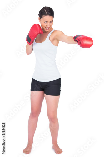 Smiling slender model with boxing gloves punching