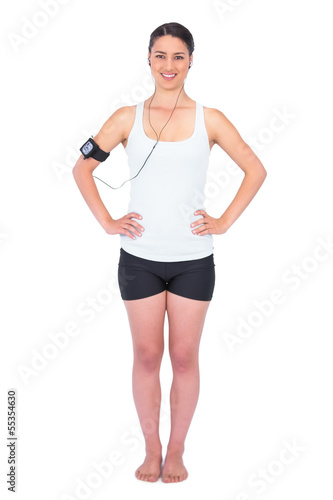 Cheerful slender model wearing armband holding mp3 player