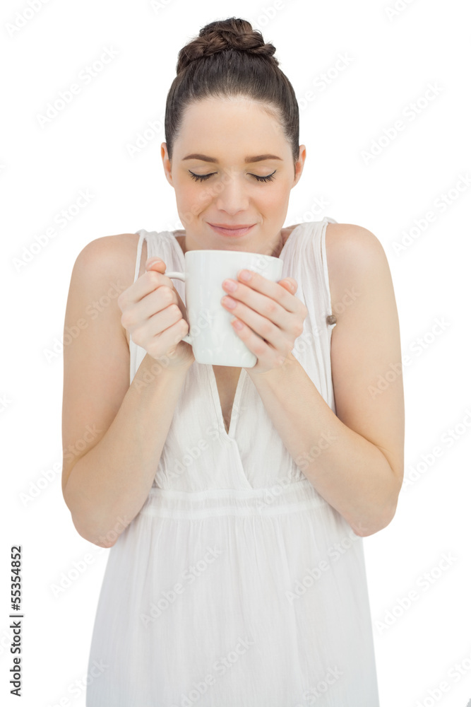Cheerful model in white dress smelling coffee Cheerful model in white dress smelling coffee