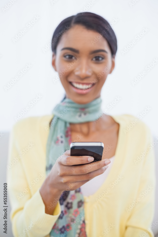 Happy elegant woman sitting on sofa text messaging Happy elegant woman sitting on sofa text messaging