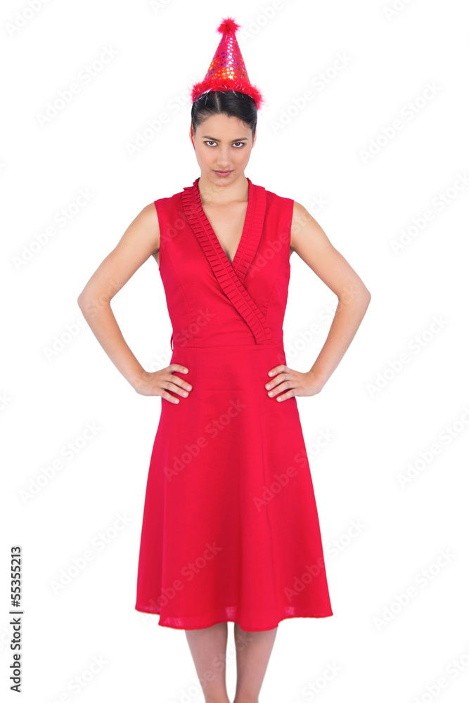 Serious gorgeous brunette in red dress wearing party hat Serious gorgeous brunette in red dress wearing party hat