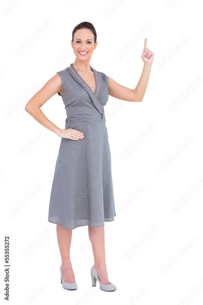 Smiling gorgeous woman in classy dress pointing her finger up Smiling gorgeous woman in classy dress pointing her finger up