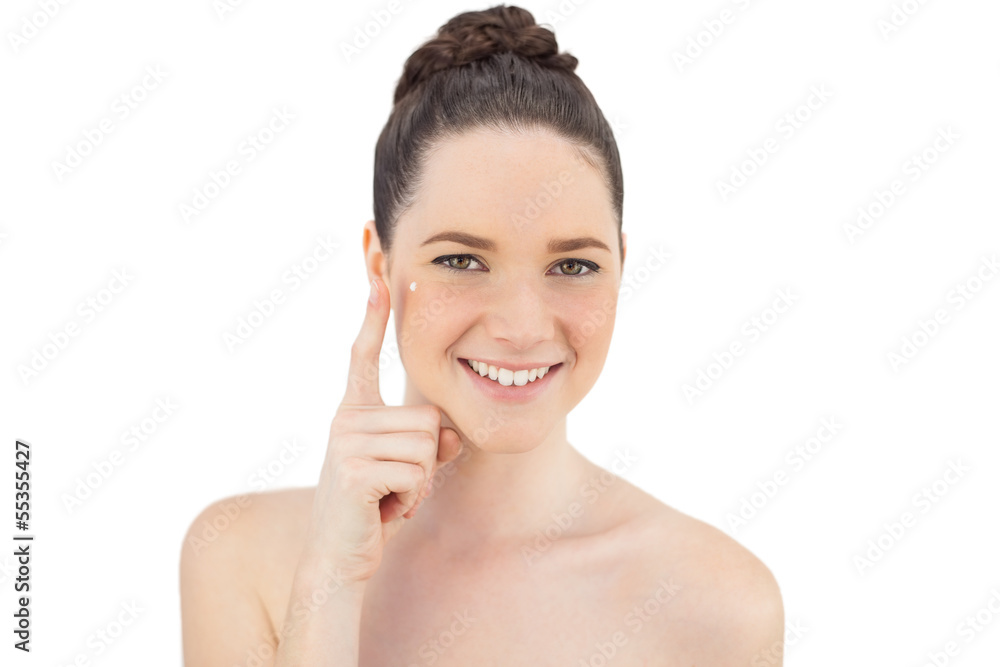 Cheerful natural model applying cream on her crows feet Cheerful natural model applying cream on her crows feet