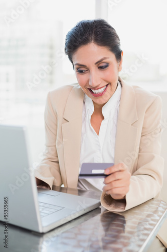 Cheerful businesswoman shopping online with laptop © lightwavemedia