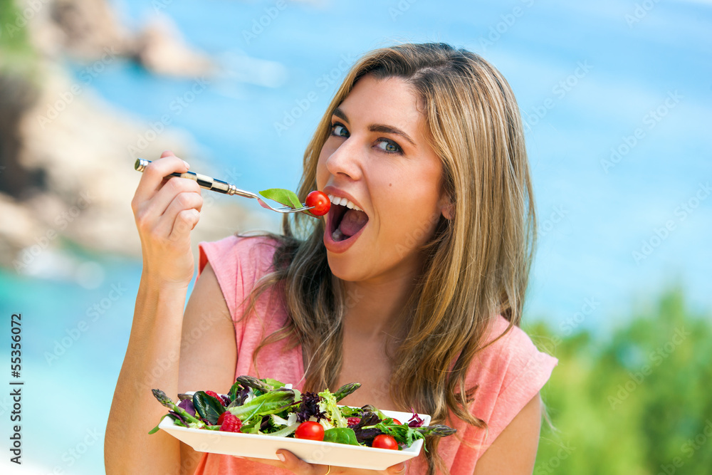Attractive woman eating green salad. Attractive woman eating green salad.