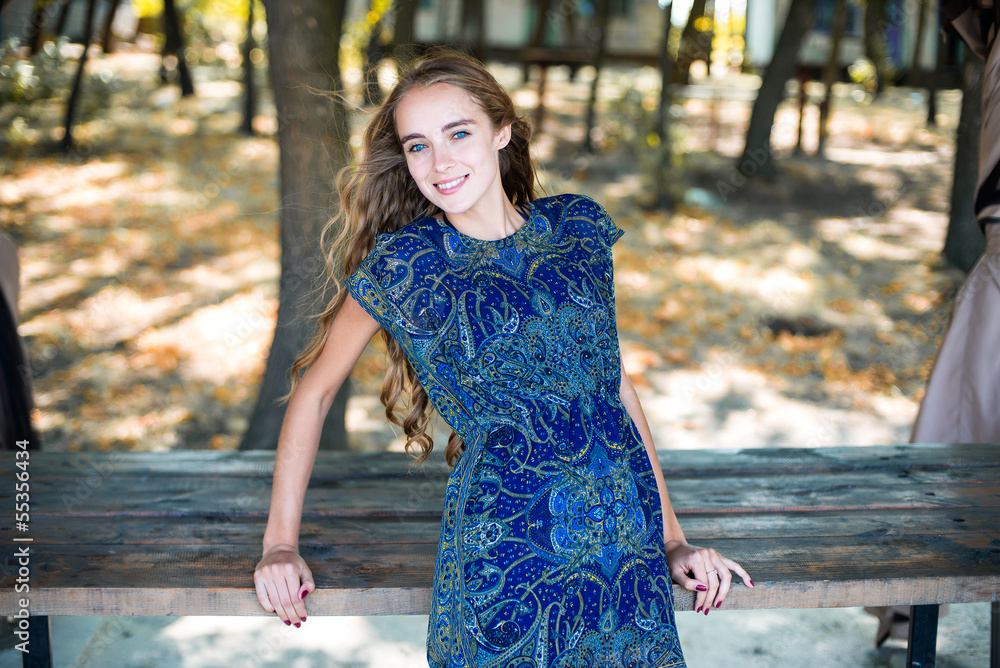 Beautiful smiling woman with long hair standing in the park Beautiful smiling woman with long hair standing in the park