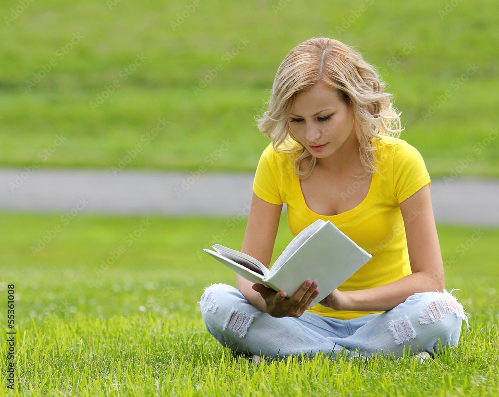 Girl reading book. beautiful blonde with book sitting on grass Girl reading book. beautiful blonde with book sitting on grass