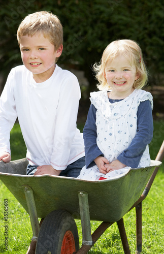 Two Children Sitting In Wheelbarrow