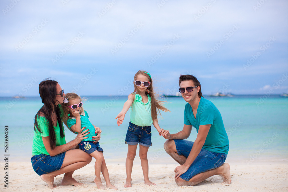 Young beautiful family of four enjoyed relaxing on the beach