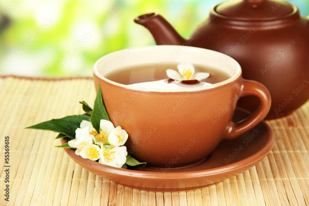 Cup of tea with jasmine, on bamboo mat, on bright background Cup of tea with jasmine, on bamboo mat, on bright background