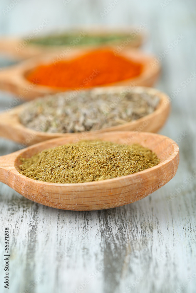 Assortment of spices in wooden spoons on wooden background Assortment of spices in wooden spoons on wooden background