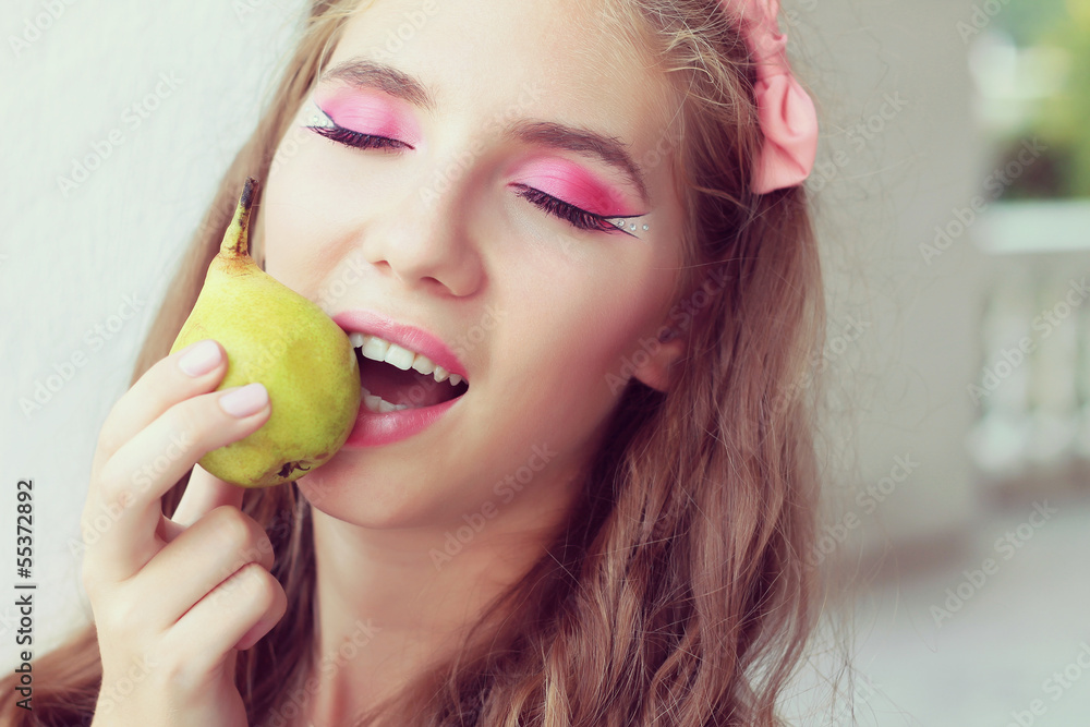 beautiful girl eating a pear. fashion portrait outdoors. beautiful girl eating a pear. fashion portrait outdoors.
