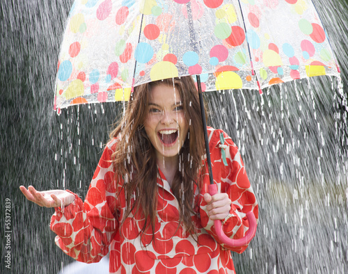 Fotografia Teenage Girl Sheltering From Rain Beneath Umbrella