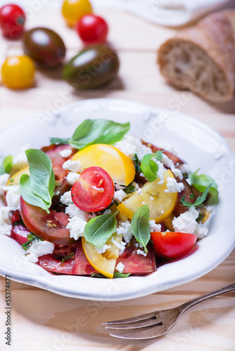 salad with red, yellow and black tomatoes and feta cheese