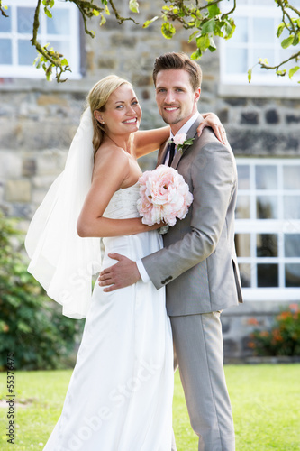 Romantic Bride And Groom Embracing Outdoors