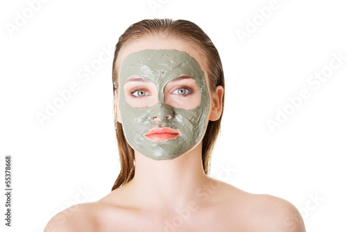 Beautiful woman with clay facial mask  isolated on white