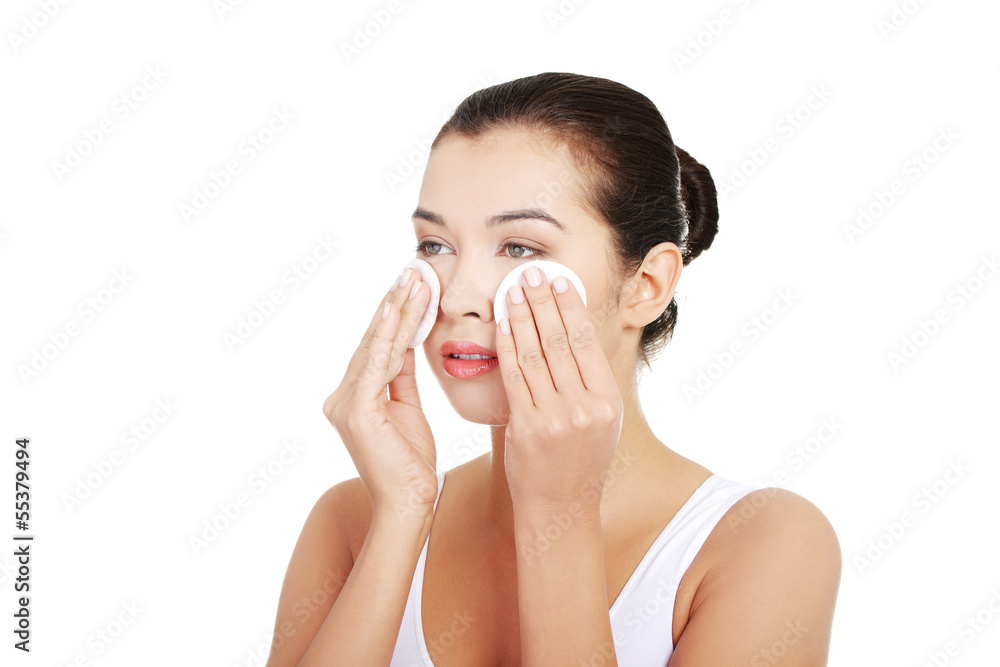 Portrait of happy young woman cleaning skin by cotton pad Portrait of happy young woman cleaning skin by cotton pad