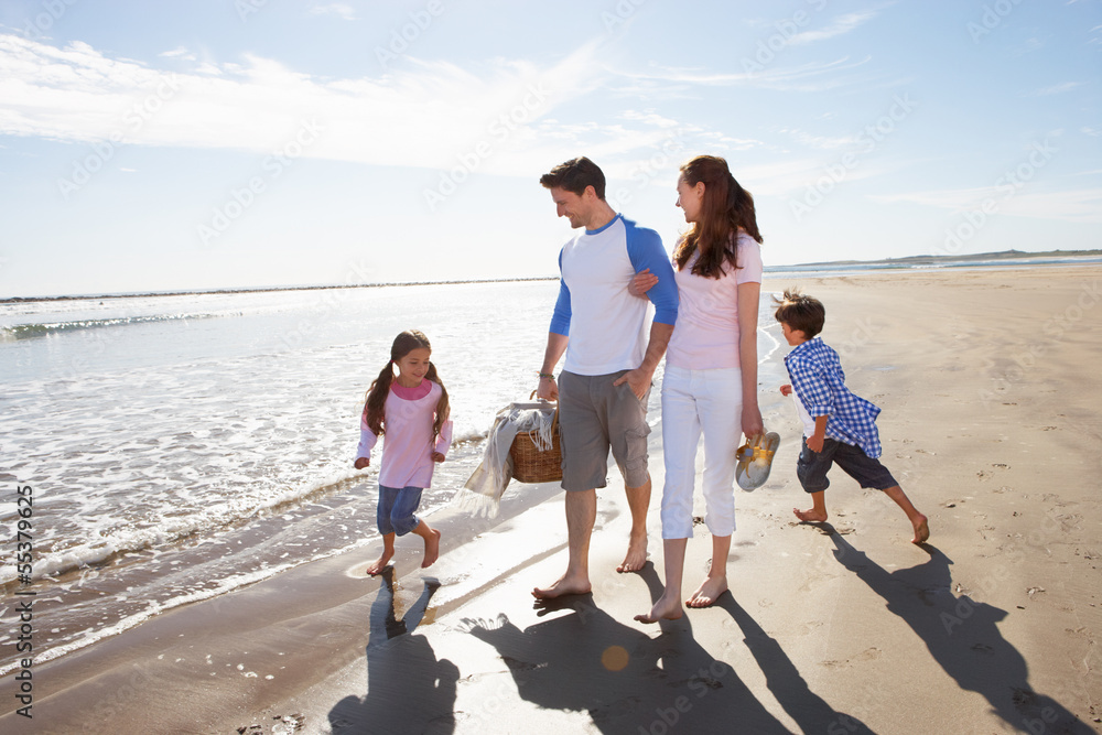 Family Walking Along Beach With Picnic Basket Family Walking Along Beach With Picnic Basket