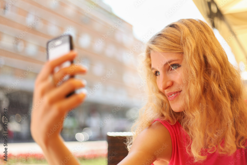 Young woman taking selfie on cell phone Young woman taking selfie on cell phone
