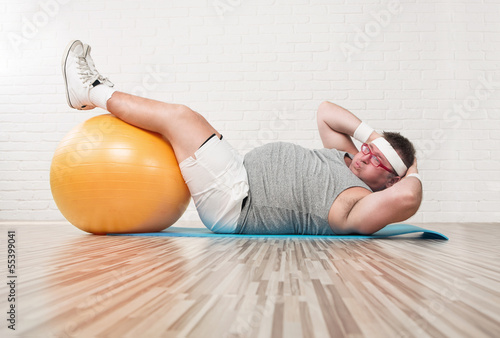 Canvas Print Funny overweight man working out in the gym
