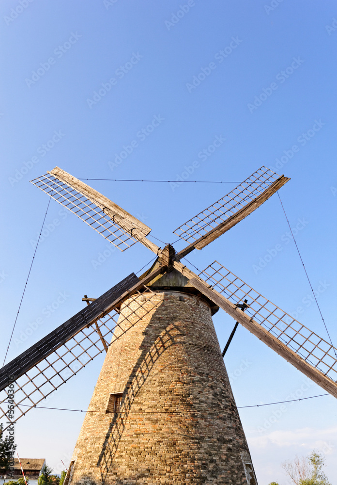 Old wooden mill against the blue sky